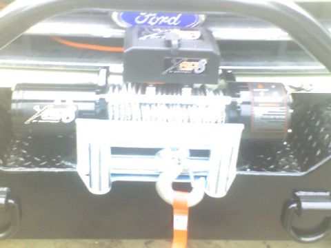 1989 Ford Bronco - A winch is mounted to the front bumper of a Ford Bronco, ready for off-road use.