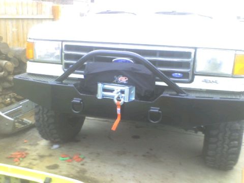 1989 Ford Bronco - Front view of a white truck's aftermarket bumper, winch, and brush guard. A 4x4 badge is visible on the grille.
