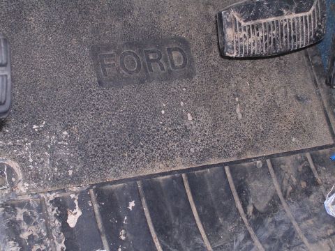 1979 Ford F-150 - Embossed FORD logo on a worn floor mat, with visible brake and gas pedals.