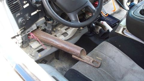 1979 Chevrolet Blazer - The interior of a vehicle shows a steering wheel, dashboard, and exposed wiring, with a metal pipe extending from the dash.