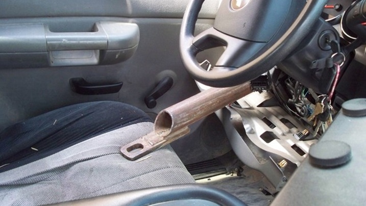 Interior view of a vehicle with a metal pipe inserted into the steering column