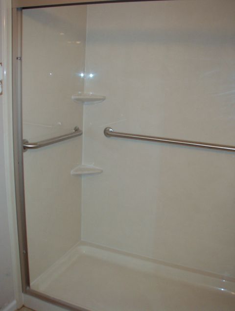 2004 Land Rover Land Rover - Interior view of a shower stall with grab bars and built-in shelves.