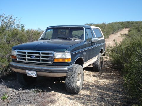 1993 Ford Bronco - This 1993 Ford Bronco is parked on a dirt road in a brushy area.