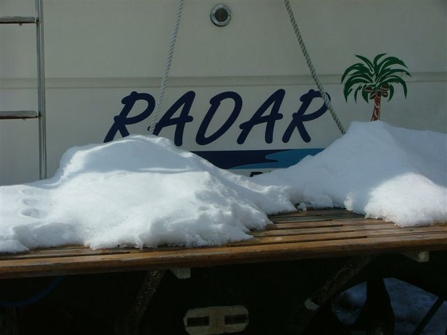 Boat named RADAR with a palm tree decal, covered in snow