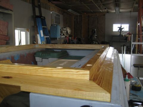 1996 Ford Bronco - The interior of a vehicle shows unfinished wooden trim and storage bins, suggesting ongoing construction or modification.