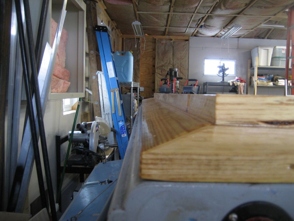 Garage interior with tools, lumber, and a blue ladder