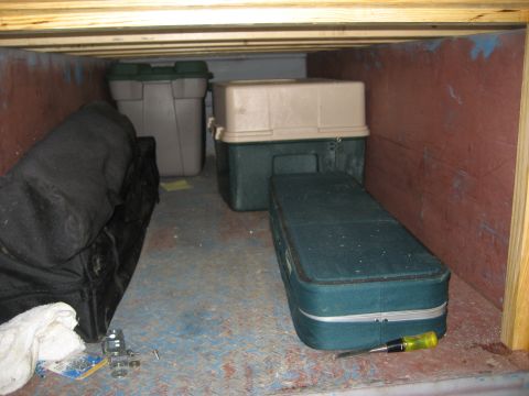 1996 Ford Bronco - Various storage containers and bags are organized within a confined, wooden-lined space.