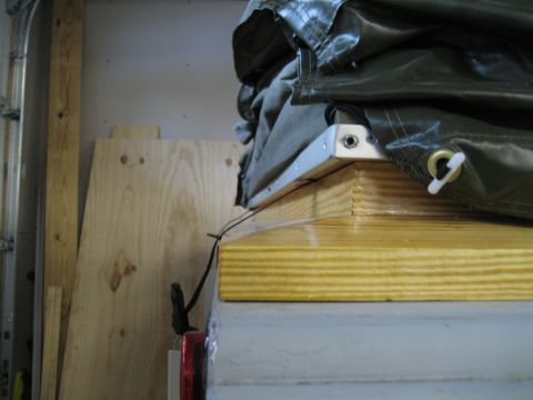 1996 Ford Bronco - A trailer's top is covered by a green tarp, revealing wooden supports and metal framing details.
