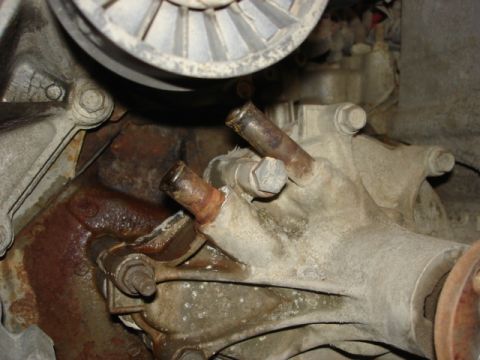 1992 Ford Bronco - Engine water pump shows signs of corrosion and wear, with visible pipes and a pulley.
