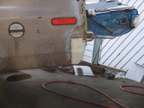 1973 Ford Ranchero - The rear section of a vehicle is undergoing repair work, with exposed metal and a detached blue component.