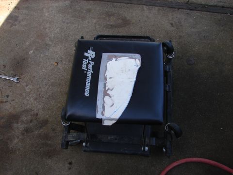 1973 Ford Ranchero - A mechanic's creeper is shown with a piece of metal taped to its seat. The creeper has a "P Performance Tool" logo.