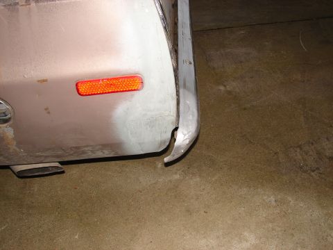 1973 Ford Ranchero - The rear bumper of a vehicle is bent and damaged, showing signs of repair work on the quarter panel.