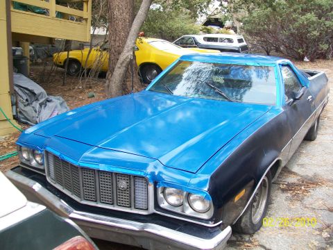 1973 Ford Ranchero - A blue and black Ford Ranchero is parked outside with other vehicles.