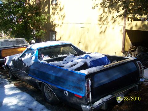 1973 Ford Ranchero - A snow-covered Ford Ranchero is parked next to another vehicle on a sunny day.