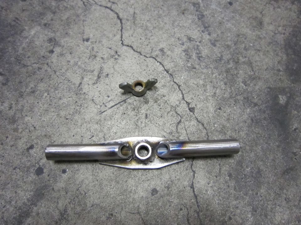 Metal part with holes and a wing nut on concrete