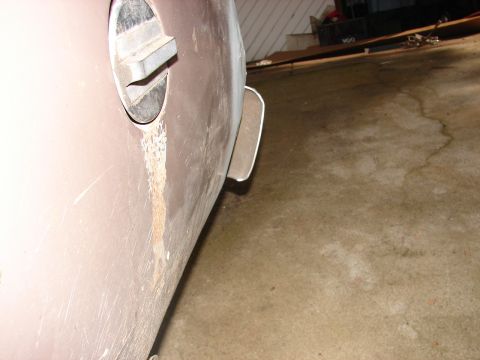 1973 Ford Ranchero - The rear quarter panel of a vehicle shows signs of rust and damage around the gas cap area.