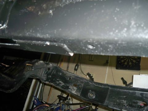 1985 Ford Bronco - The underside of a vehicle's frame is shown, with parts of the suspension visible.