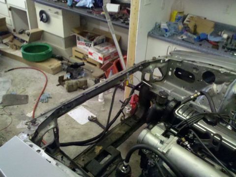 1986 Ford Mustang - The engine bay of a 1986 Ford Mustang shows signs of ongoing repair work, with components disassembled.