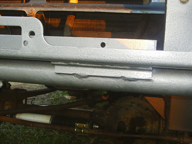 Silver textured-paint front bumper close-up with steering linkage and stabilizer visible underneath