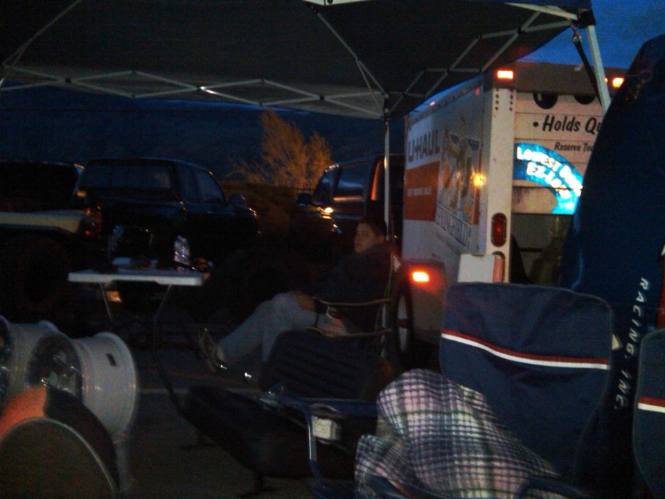 U-Haul truck and other vehicles parked under a canopy at dusk