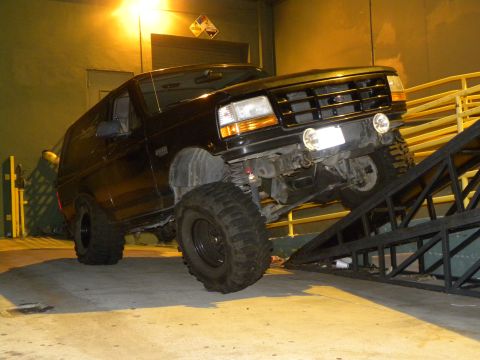 1995 Ford Bronco - This 1995 Ford Bronco is shown with a lifted suspension and large tires, ascending a metal ramp.