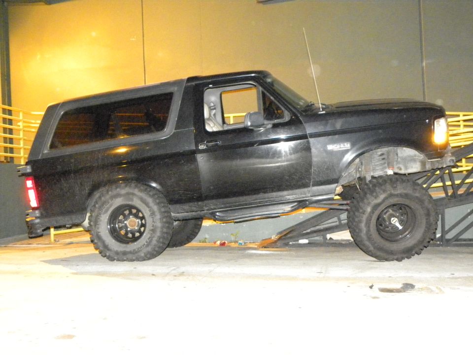 Black Ford Bronco with lifted suspension and off-road tires on a ramp