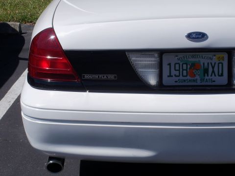 2003 Ford Crown Victoria - Rear view of a white 2003 Ford Crown Victoria showing the taillight and license plate.