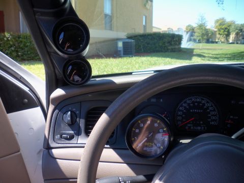 2003 Ford Crown Victoria - Aftermarket gauges are installed on the A-pillar and steering column of this vehicle's interior.