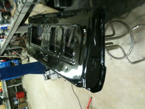 1993 Ford Bronco - A black car door is shown from the interior side, undergoing restoration or repair.