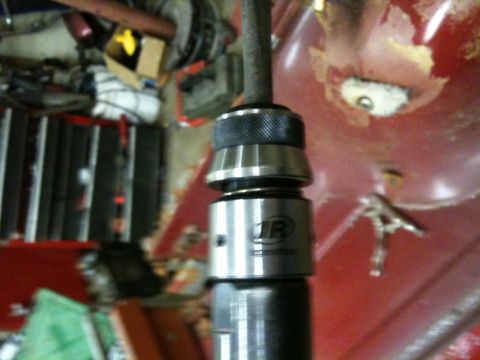 1993 Ford Bronco - A close-up view of a drill bit and chuck assembly, with a red surface visible in the background.