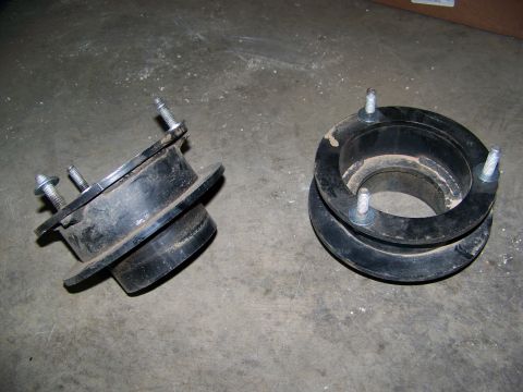 2001 Dodge 1500 - Two black suspension lift spacers are shown on a concrete floor. The website "Supermotors.net" is visible in the lower right corner.