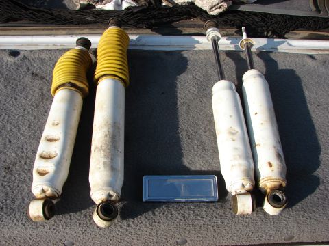1995 Ford Bronco - Set of four shock absorbers, two with yellow dust boots, displayed for sale.