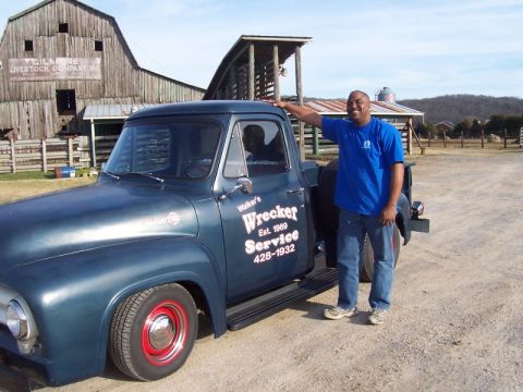 2007 Ford Mustang - Man poses with a vintage blue pickup truck that has 'Wrecker Service' painted on its side.