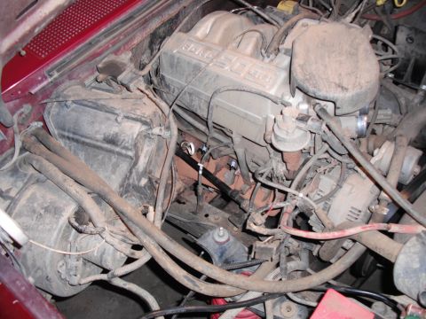 1991 Ford Bronco - A close-up view of a dusty engine bay shows various mechanical components and wiring.