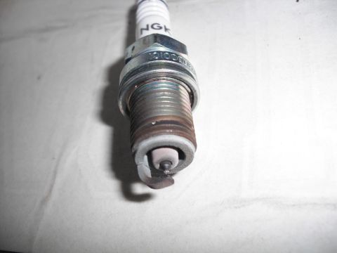 1991 Ford Bronco - A close-up view of a used NGK spark plug, showing wear on the electrode.