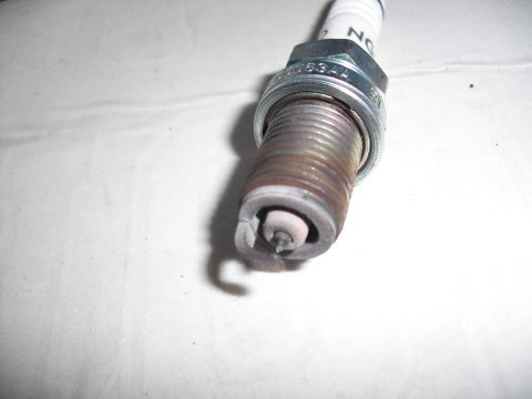 1991 Ford Bronco - A close-up view of a used spark plug, indicating it is a vehicle part rather than a complete vehicle.