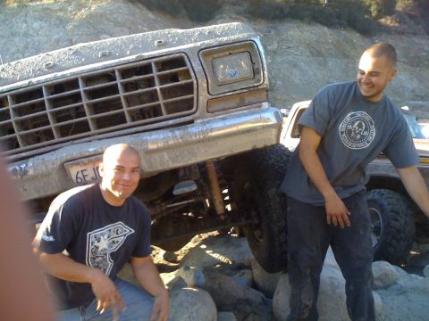 1976 Ford F-250 - Two men pose with a muddy Ford F-Series truck on a rocky terrain.