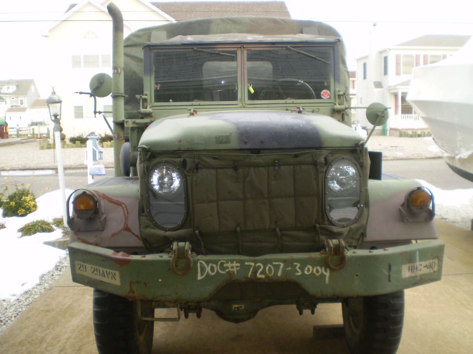 Front view of a camouflage military truck with "DOC# 7207-3004" on bumper