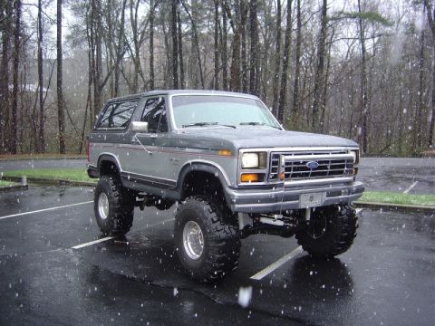 1986 Ford Bronco - This lifted 1986 Ford Bronco is seen parked in a lot as snow falls around it.