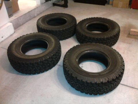 1983 Ferrari Enzo - Four off-road tires are shown on a concrete floor.