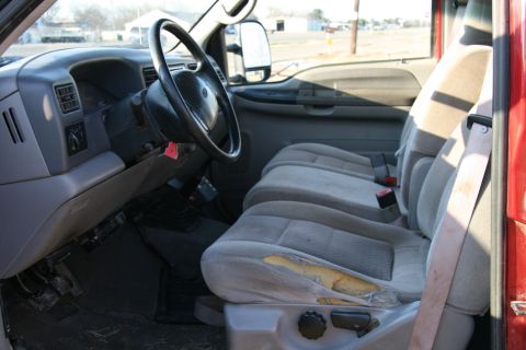 1993 Ford Bronco - The interior of a truck shows a torn driver's seat, dashboard, and passenger seats.