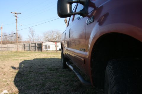 1993 Ford Bronco - Side view of a red truck, showing the F350 badge and running board.