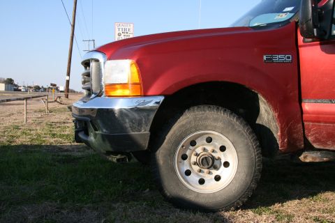 1993 Ford Bronco - A red Ford F-350 Super Duty truck is parked outdoors, with a tire and fender in the foreground.