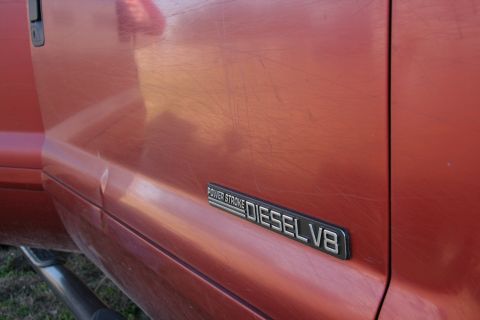 1993 Ford Bronco - Door badge reads 'POWER STROKE DIESEL V8' on a red Ford truck.