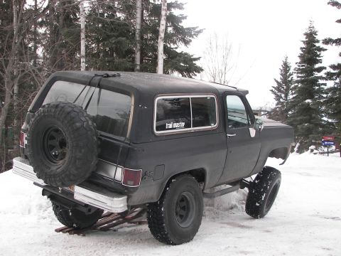 1990 Chevrolet Suburban - This lifted Chevrolet K5 Blazer is parked in a snowy outdoor setting with a spare tire on the back.