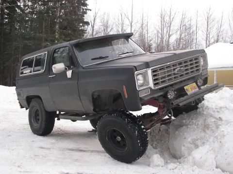 1990 Chevrolet Suburban - This lifted Chevrolet K5 Blazer is stuck in a large snowdrift, with its front end elevated.