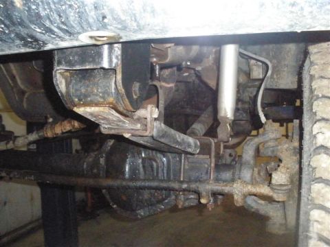 1994 Ford F-350 - Undercarriage view of a truck's suspension system, focusing on the leaf spring mount.