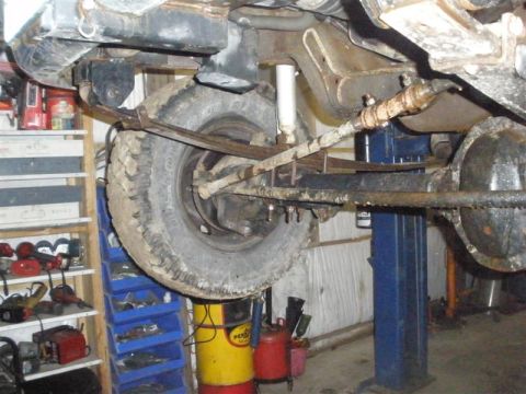 1994 Ford F-350 - Close-up view of the front suspension and steering components of a vehicle undergoing service.