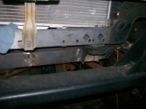 1989 Ford Bronco - The front frame and radiator support of a vehicle are shown, with visible signs of repair work.
