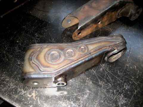 1996 Ford Bronco - Close-up of a custom-fabricated metal steering part, showing intricate welding and design details.